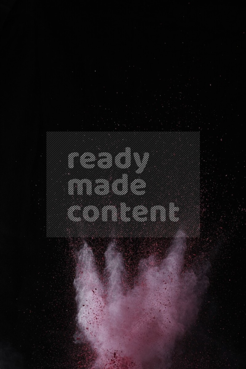 A side view of red powder explosion on black background