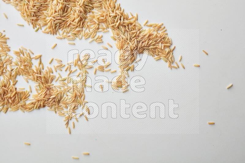 Top-view shot of long grain brown rice on white background