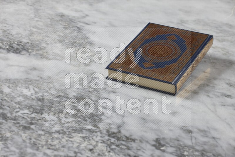 Quran with a prayer beads on grey marble background
