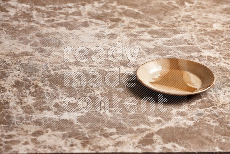 A multicolored pottery plate on beige marble background