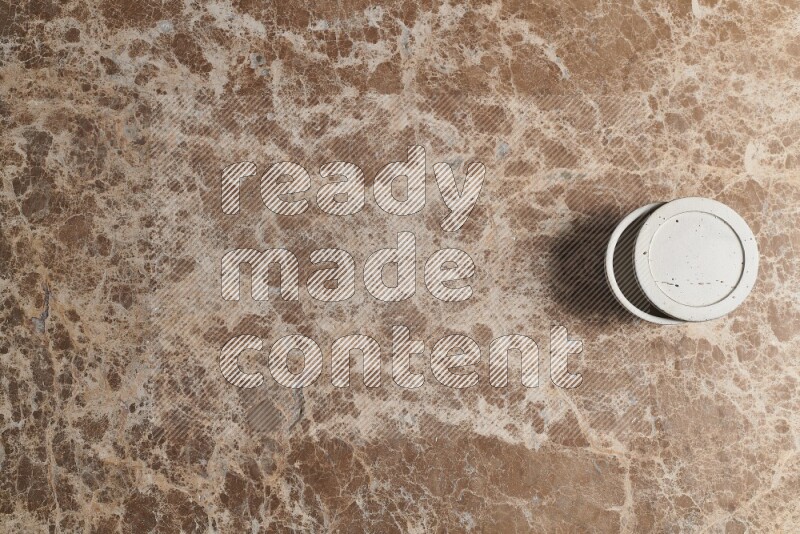 A pottery cup on beige marble background