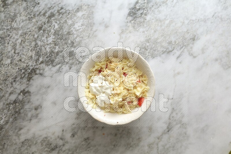 White bowl full of pasta on grey marble background