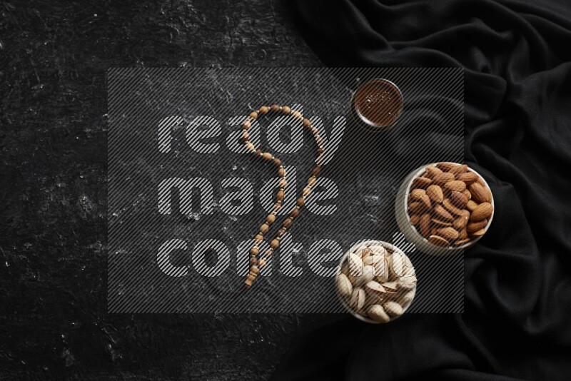 Nuts in pottery bowls with coffee in a dark setup