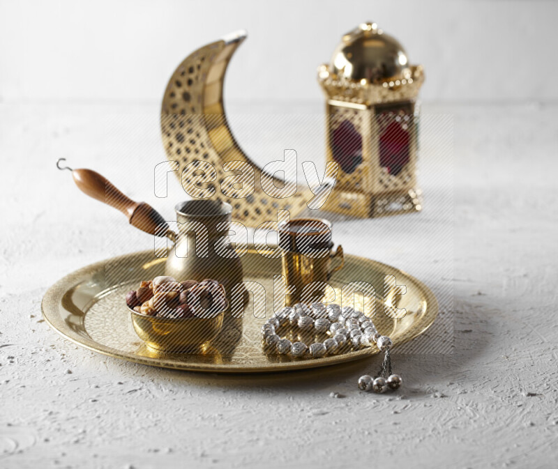 مكسرات في وعاء معدني مع قهوة وسبحة على صينية بجانب فوانيس علي خلفية بيضاء