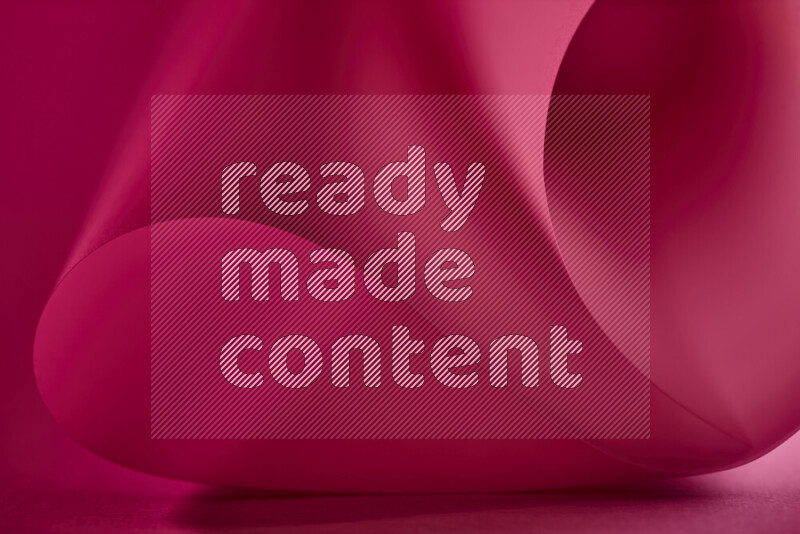 An abstract art piece displaying smooth curves in red gradients created by colored light