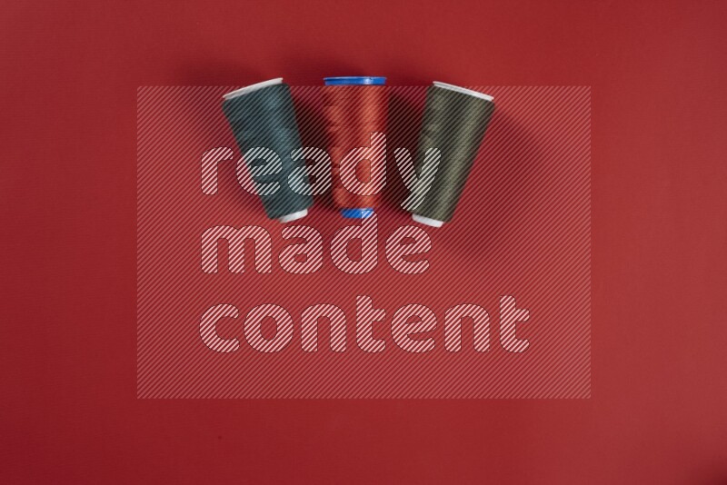 A green and red collection of sewing and tailoring tools arranged on a red background