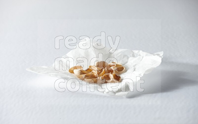 Pistachio peels on a crumpled piece of paper on a white background in different angles