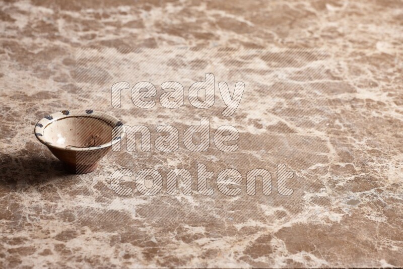A decorative pottery bowl on beige marble background
