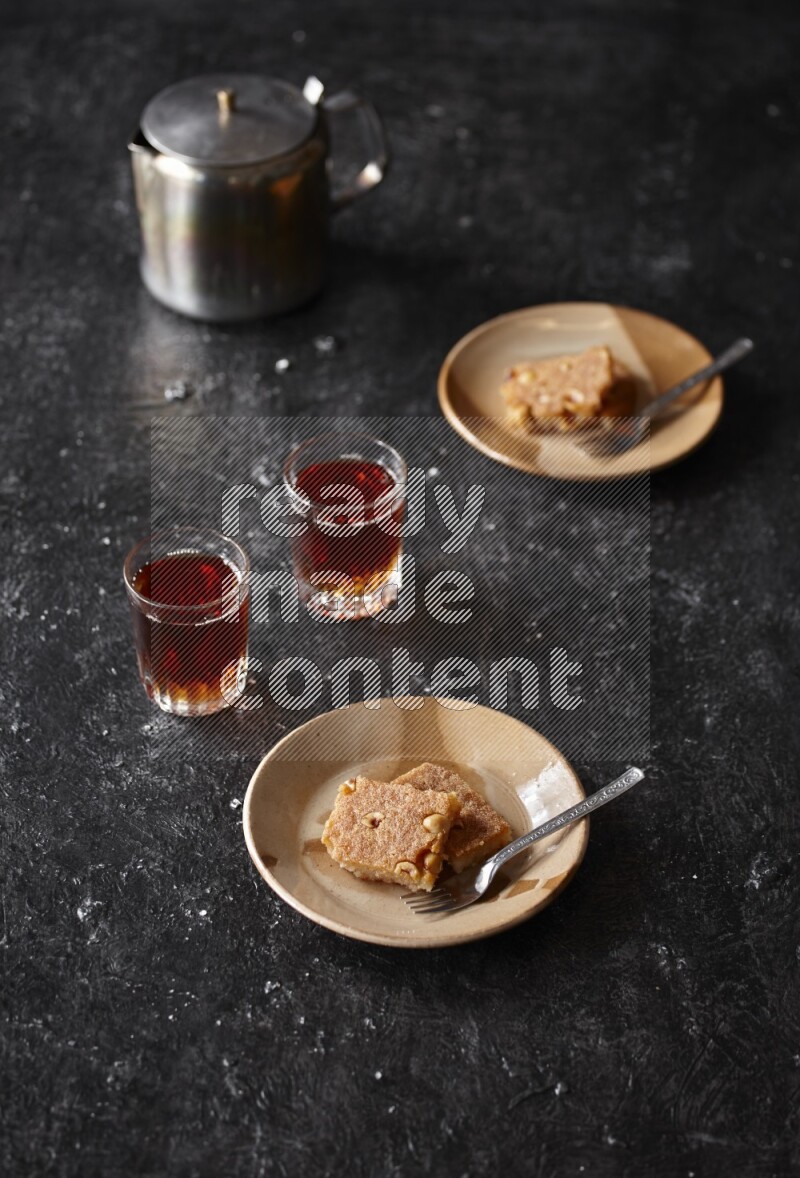 Basbousa with tea in a dark setup