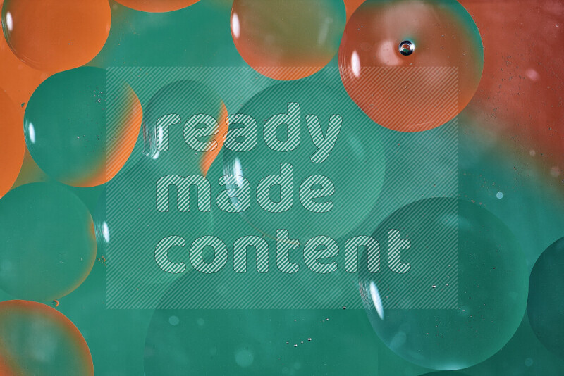 Close-ups of abstract oil bubbles on water surface in shades of green and orange