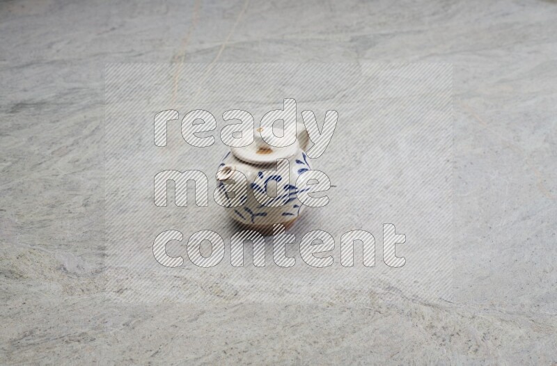 A pottery teapot on grey marble background