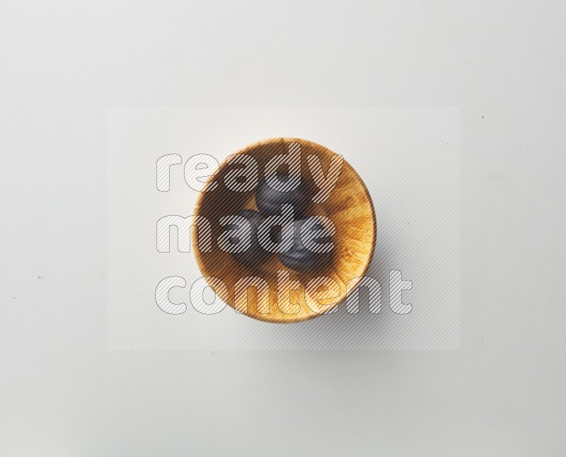 Top-view shot of dried lime (loomi) in a container on white background