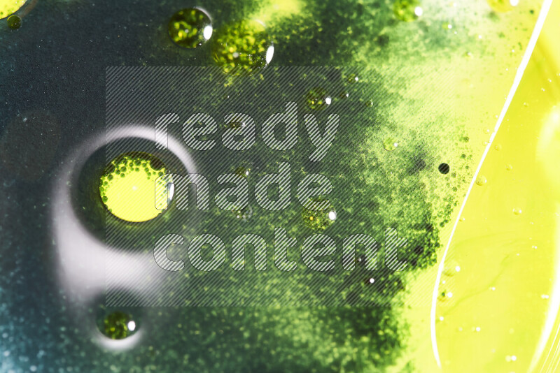 Close-ups of abstract green and yellow watercolor drops on oil Surface on white background
