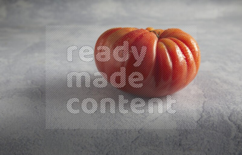45 degree single heirloom tomato on a light blue textured background