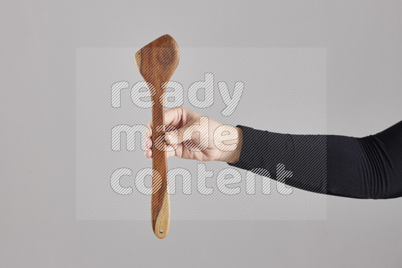 امرأة ترتدي عباءة سوداء تحمل أدوات خشبية مختلفة في أوضاع متعددة