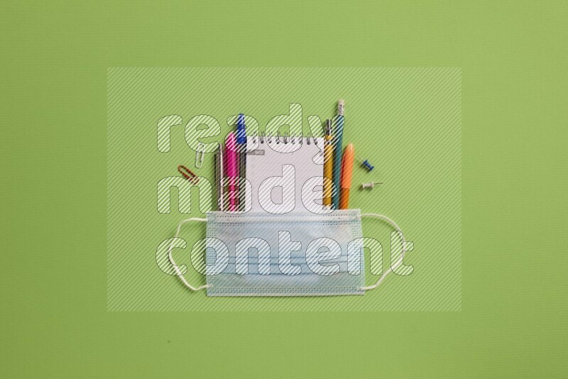 Different school supplies on green background