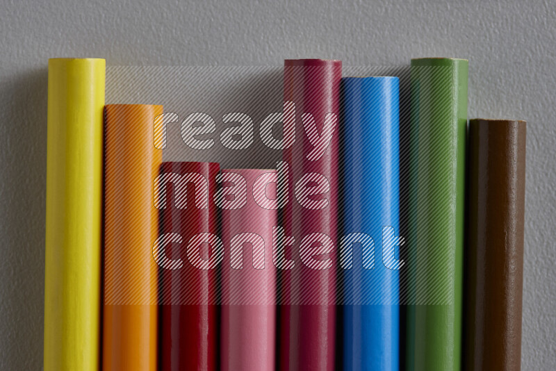 مجموعة من أقلام الرصاص الملونة مرتبة لتعرض تدرجا من الألوان المختلفة علي خلفية رمادية