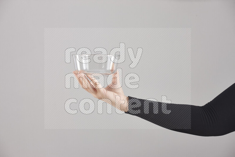 A woman in black abaya holding different glassware in different positions