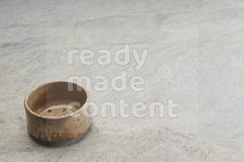A multicolored pottery bowl on grey marble background