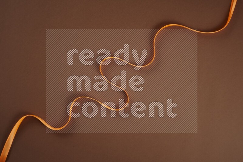 مجموعة من أدوات الخياطة والتفصيل برتقالية اللون على خلفية بنية