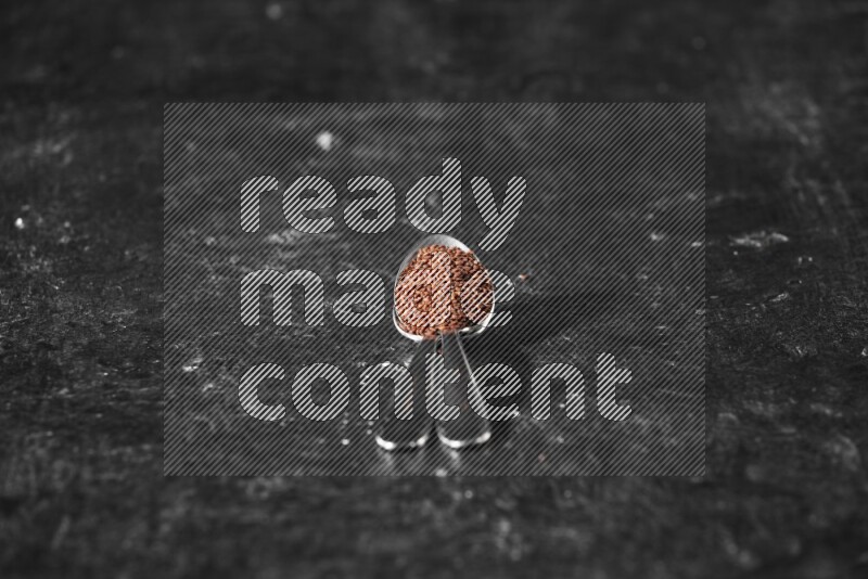 ملعقتان معدنيتان ممتلئتان ببذور حب الرشاد علي خلفية سوداء