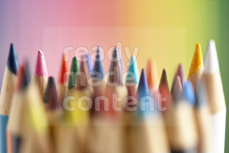 The image captures a close-up of sharpened colored pencils on multicolored background