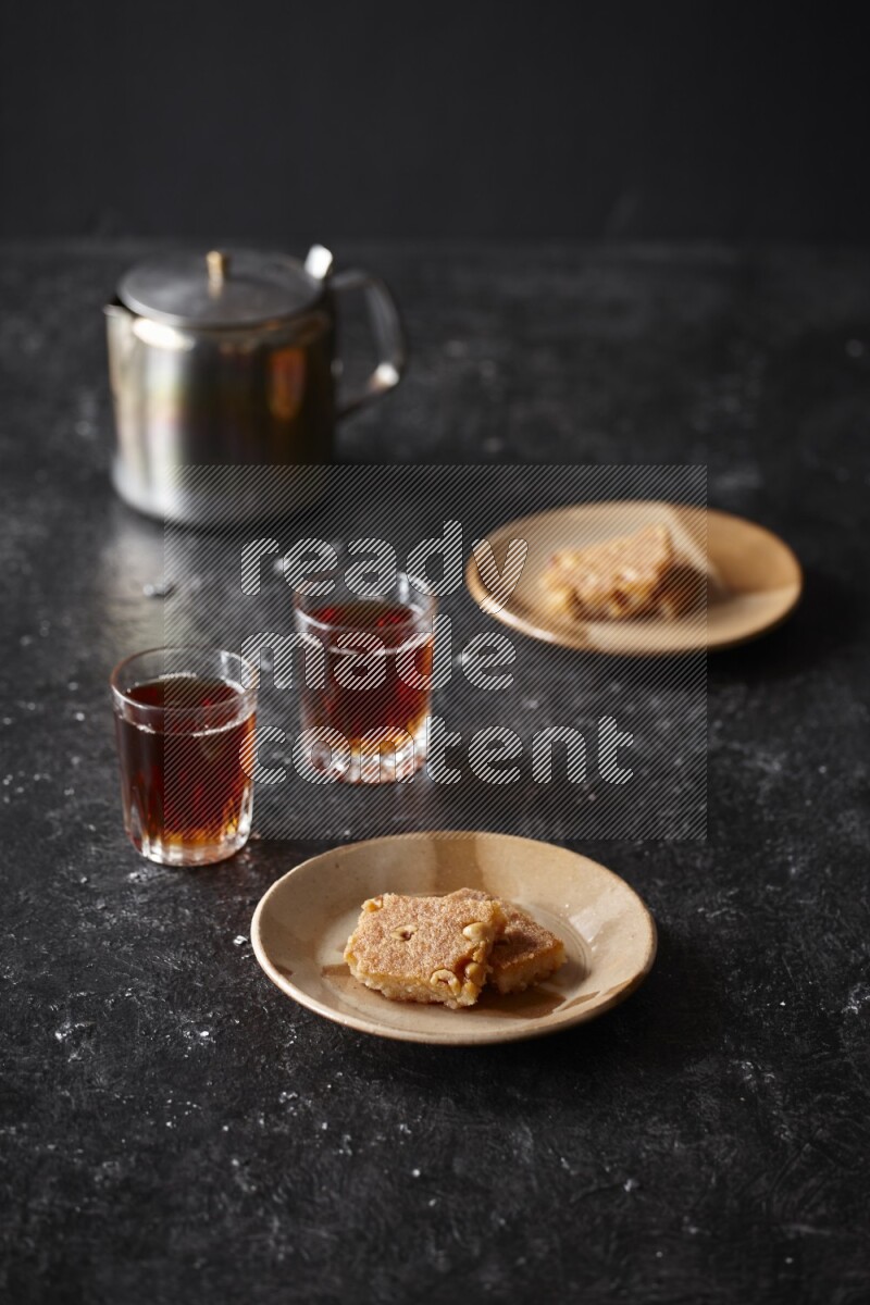 Basbousa with tea in a dark setup