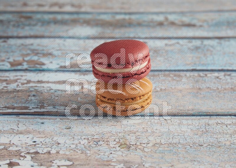 45º Shot of of two assorted Brown Irish Cream, and Red Velvet macarons on light blue background