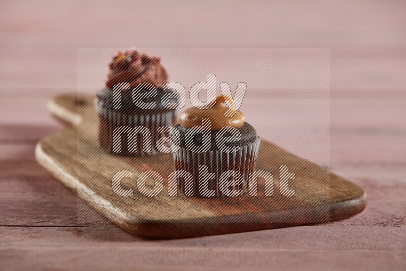 Chocolate mini cupcake topped with peanut butter on a wooden board