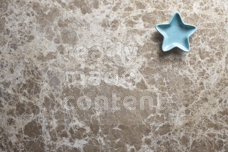 A colored pottery star plate on beige marble background
