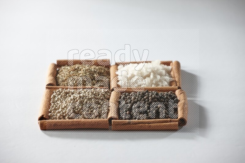 4 squares of cinnamon sticks full of cumin, salt, white pepper and black pepper on white flooring