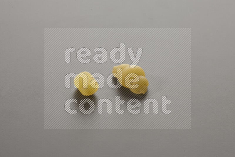 Big rings pasta with other types of pasta on grey background