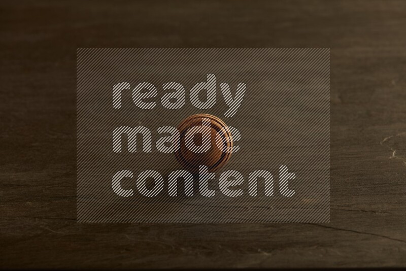 Wooden honey dipper on black slate background