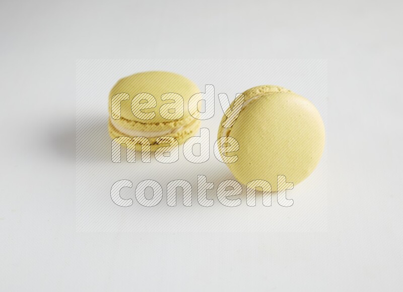 45º Shot of two Yellow Lime macarons on white background