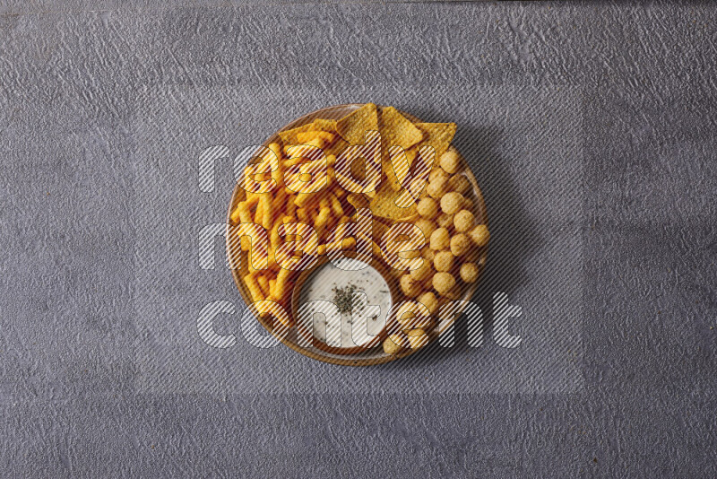 Assorted snacks in pottery bowls on grey background