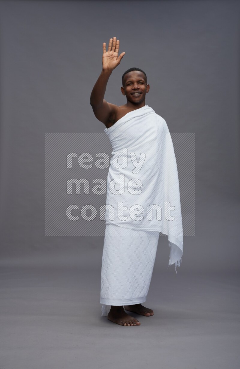 A man wearing Ehram Standing Interacting with the camera on gray background