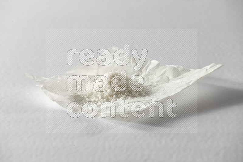 Desiccated coconut on a piece of paper on a white background in different angles