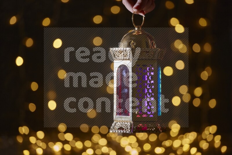 A traditional ramadan lantern surrounded by glowing fairy lights in a dark setup