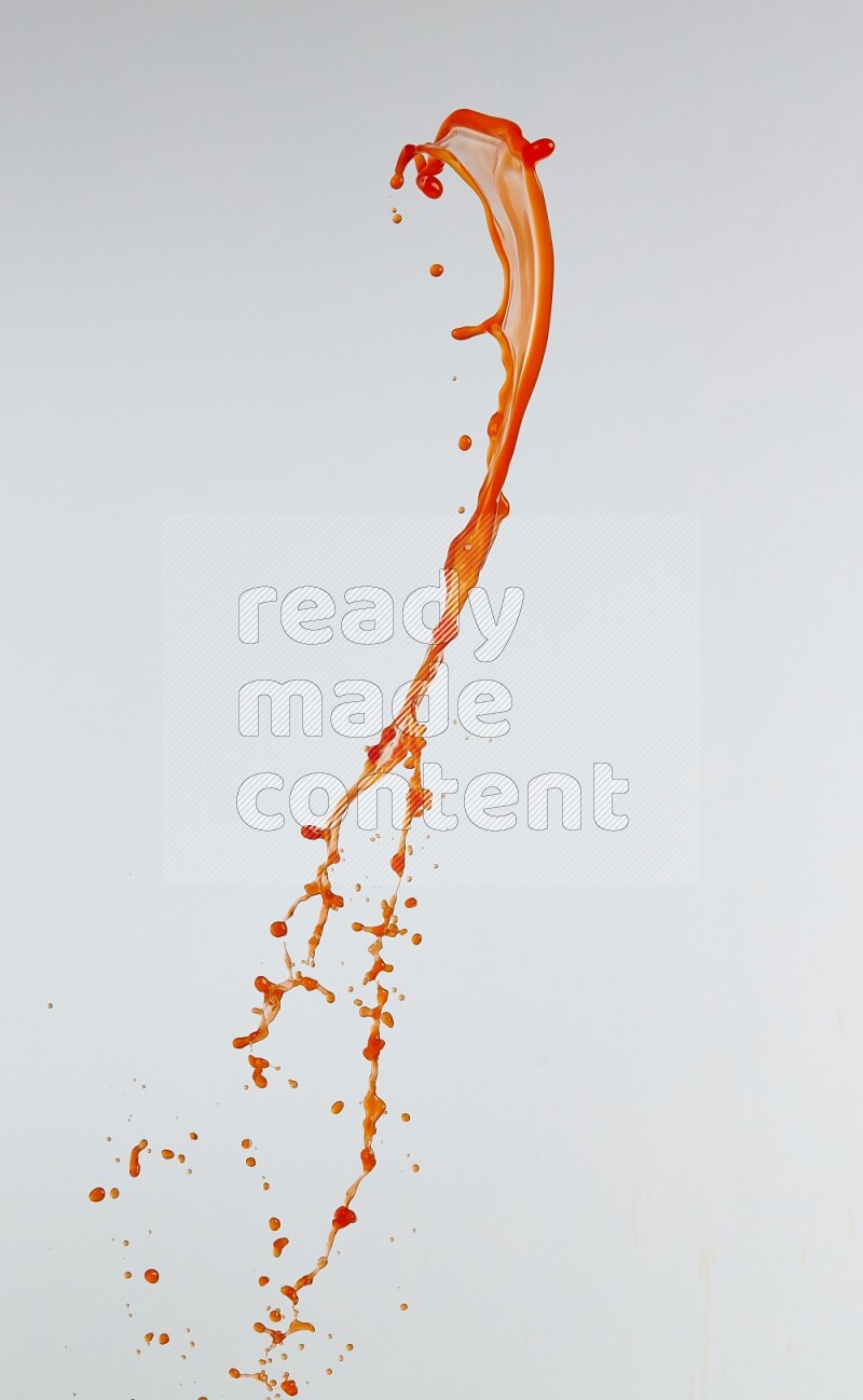 Orange liquid splash and drops on white background