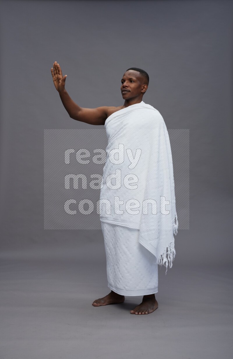 A man wearing Ehram Standing Interacting with the camera on gray background