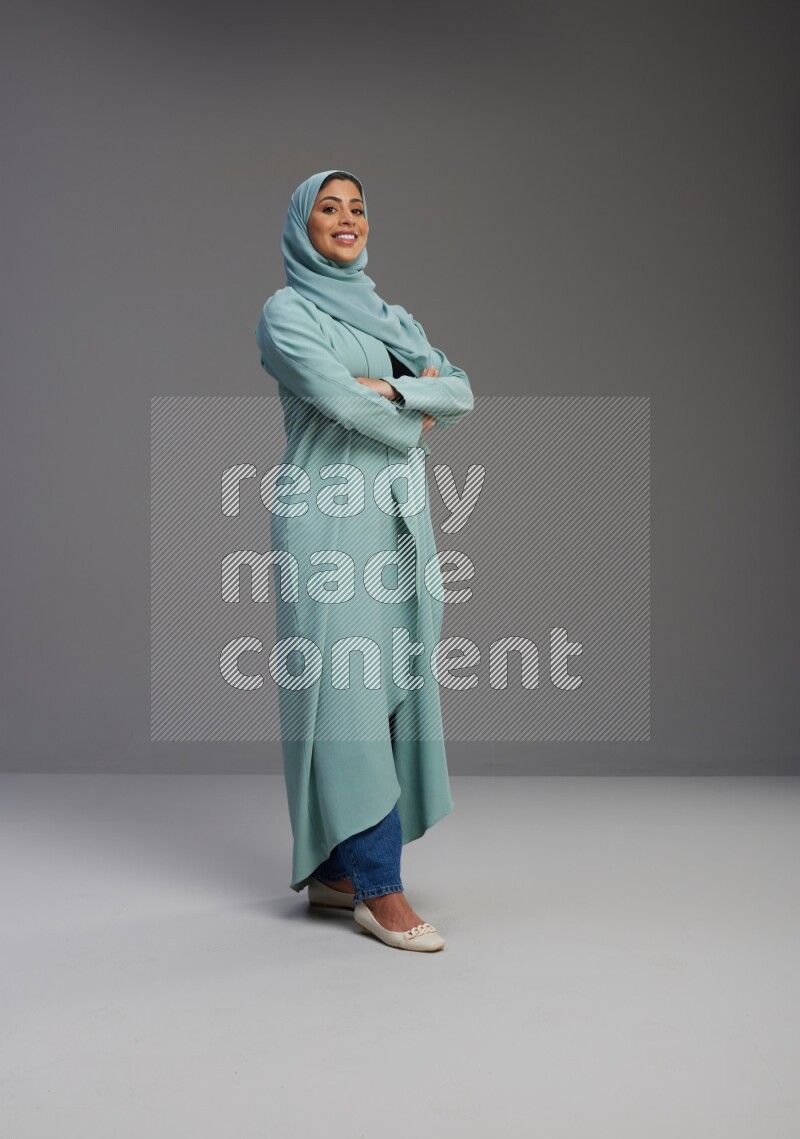 Saudi Woman wearing Abaya standing with crossed arms on Gray background