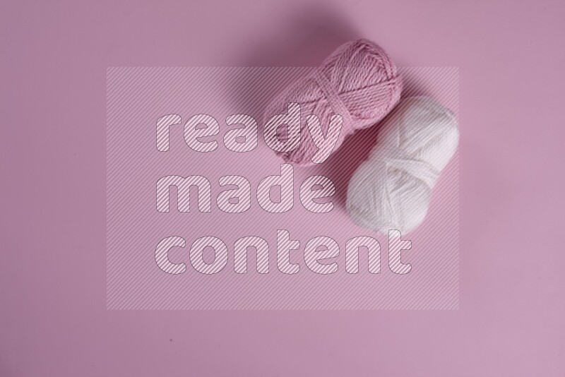 مجموعة من أدوات الخياطة والتفصيل بيضاء وزهرية اللون على خلفية زهرية