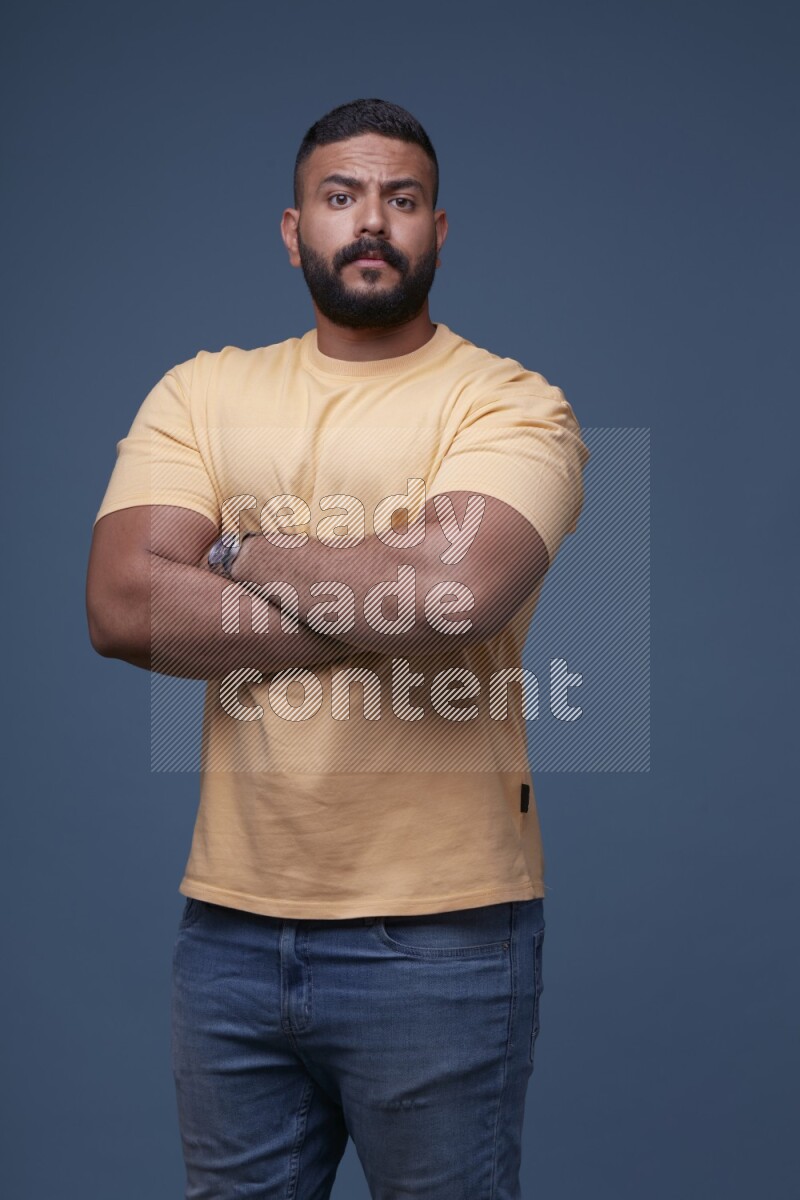 رجل يرتدي قميص اصفر بأكمام قصيرة وبنطال جينز ازرق يقف بأوضاع مختلفة