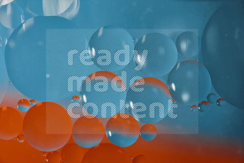 لقطات مقربة لفقاعات من الزيت على سطح الماء باللون الأزرق والبرتقالي