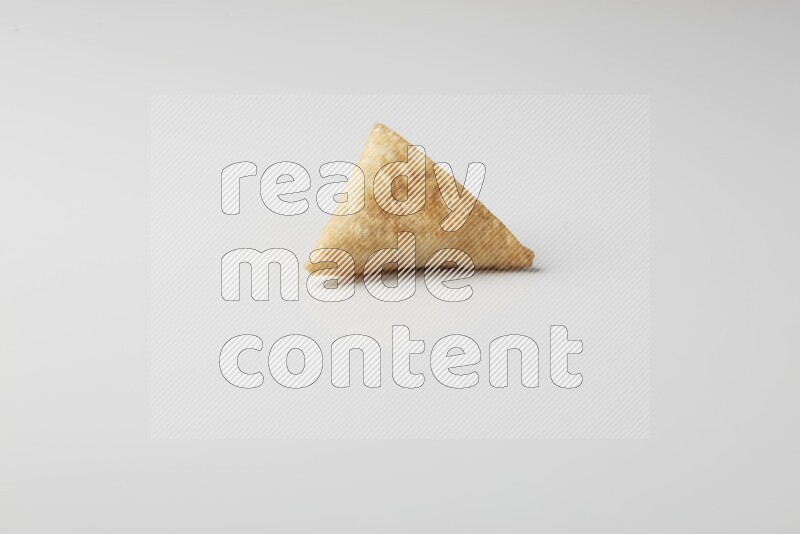 One fried sambosa on a white background