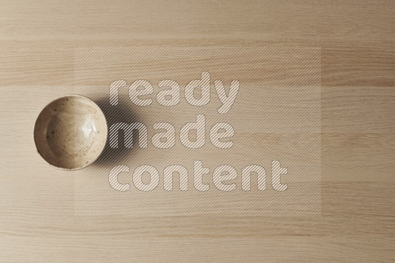 وعاء فخاري متعدد الألوان على خلفية خشبية فاتحة