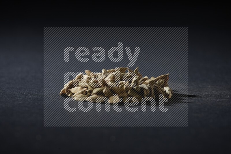 Cardamom in a circle shape on black flooring