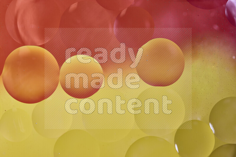 Close-ups of abstract oil bubbles on water surface in shades of red and yellow