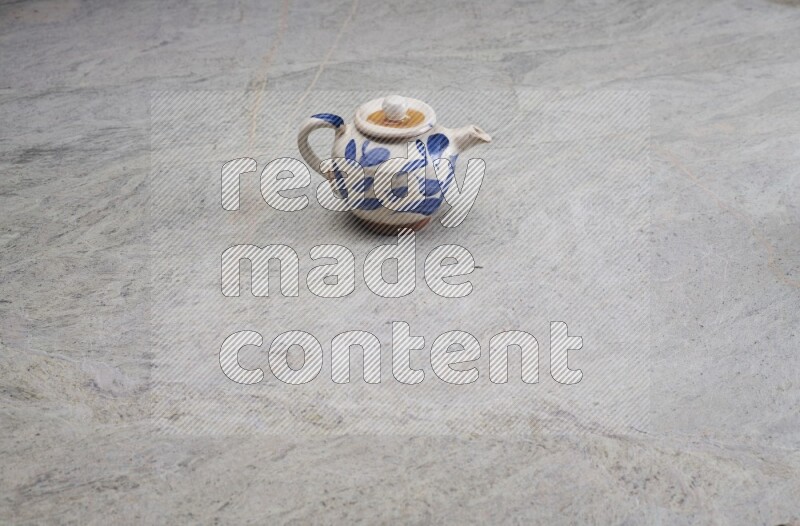 A pottery teapot on grey marble background