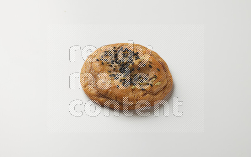 Hasawi cookie field with date and decorated by black seed and Anise grain on a white background